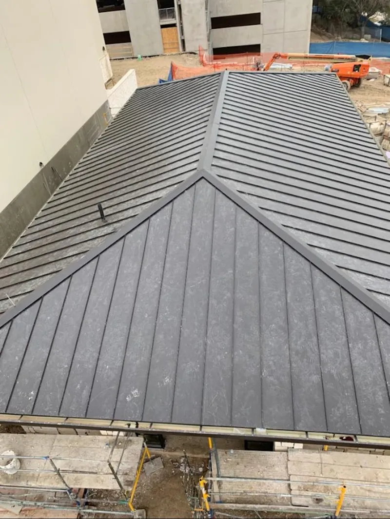 Commercial metal roof construction with crane equipment in Washington Terrace